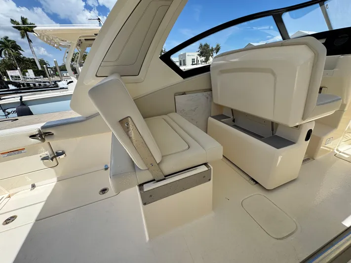  Yacht Photos Pics 2025 Scout 277 Dorado boat interior with seating and helm, docked under a clear sky.