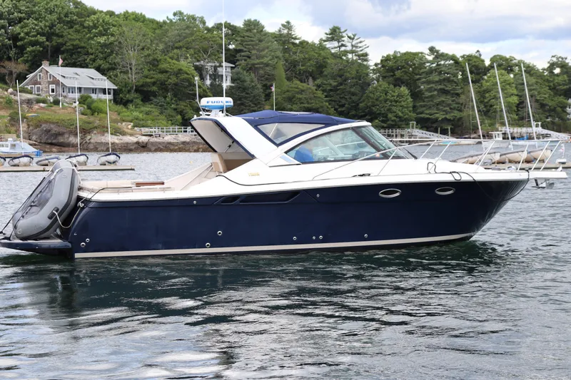 Cara Mia Yacht Photos Pics 2012 Tiara Yachts 3100 Coronet in water, surrounded by trees and boats.