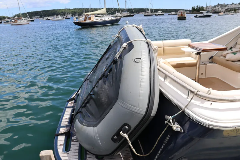 Cara Mia Yacht Photos Pics 2012 Tiara Yachts 3100 Coronet with inflatable boat on deck, docked in a scenic harbor.