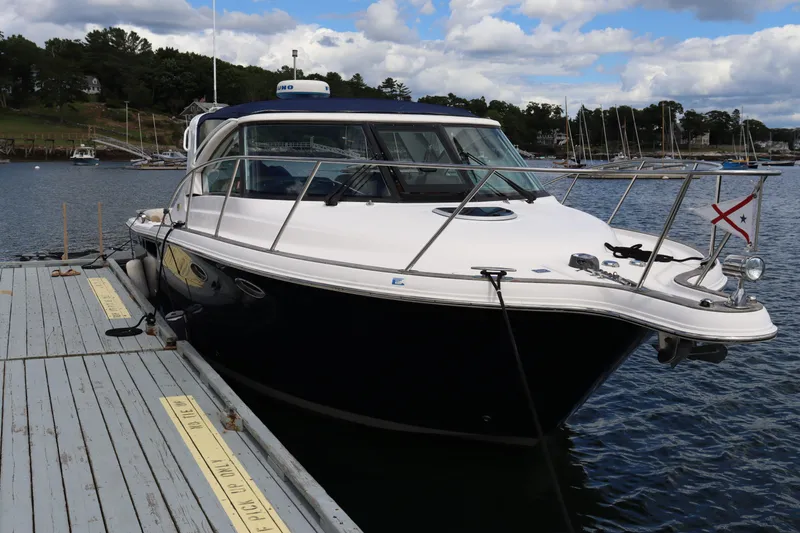 Cara Mia Yacht Photos Pics 2012 Tiara Yachts 3100 Coronet docked on a calm lake under a partly cloudy sky.