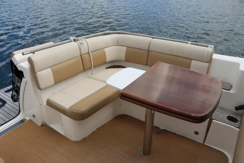 Cara Mia Yacht Photos Pics 2012 Tiara Yachts 3100 Coronet interior with cushioned seating and wooden table by the water.