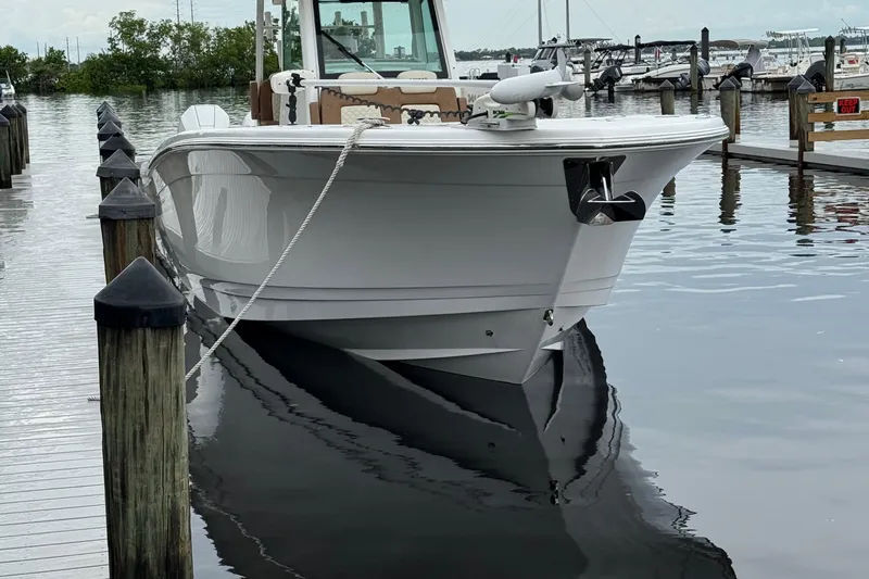 Caymas 341 Center Console Yacht Photos Pics 2020 Caymas 341 CC boat docked at marina, calm water reflection.