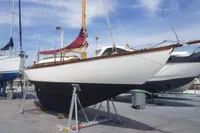 Vintage 1935 Matthiesen & Paulsen Sloop sailboat on dry dock under a clear sky.