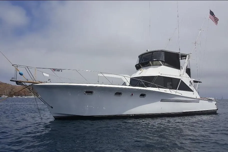1974 Pacemaker 48 Sportfisherman yacht on calm water with American flag.