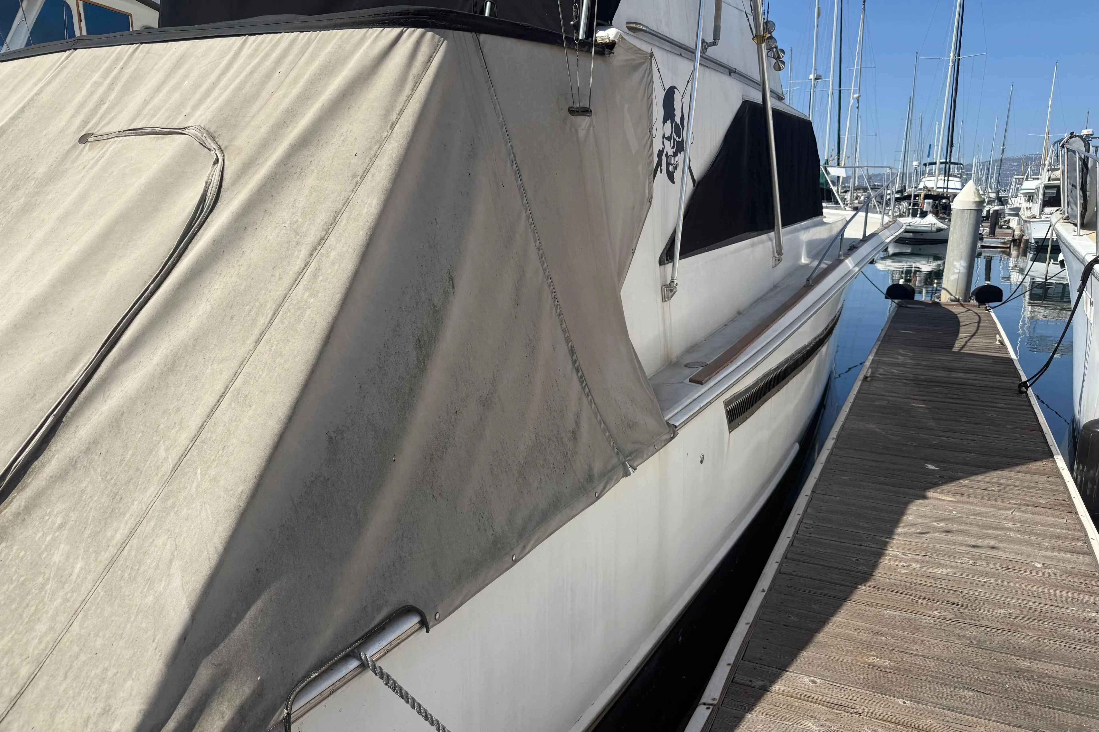 1974 Pacemaker 48 Sportfisherman yacht docked at marina, side view with canvas cover.