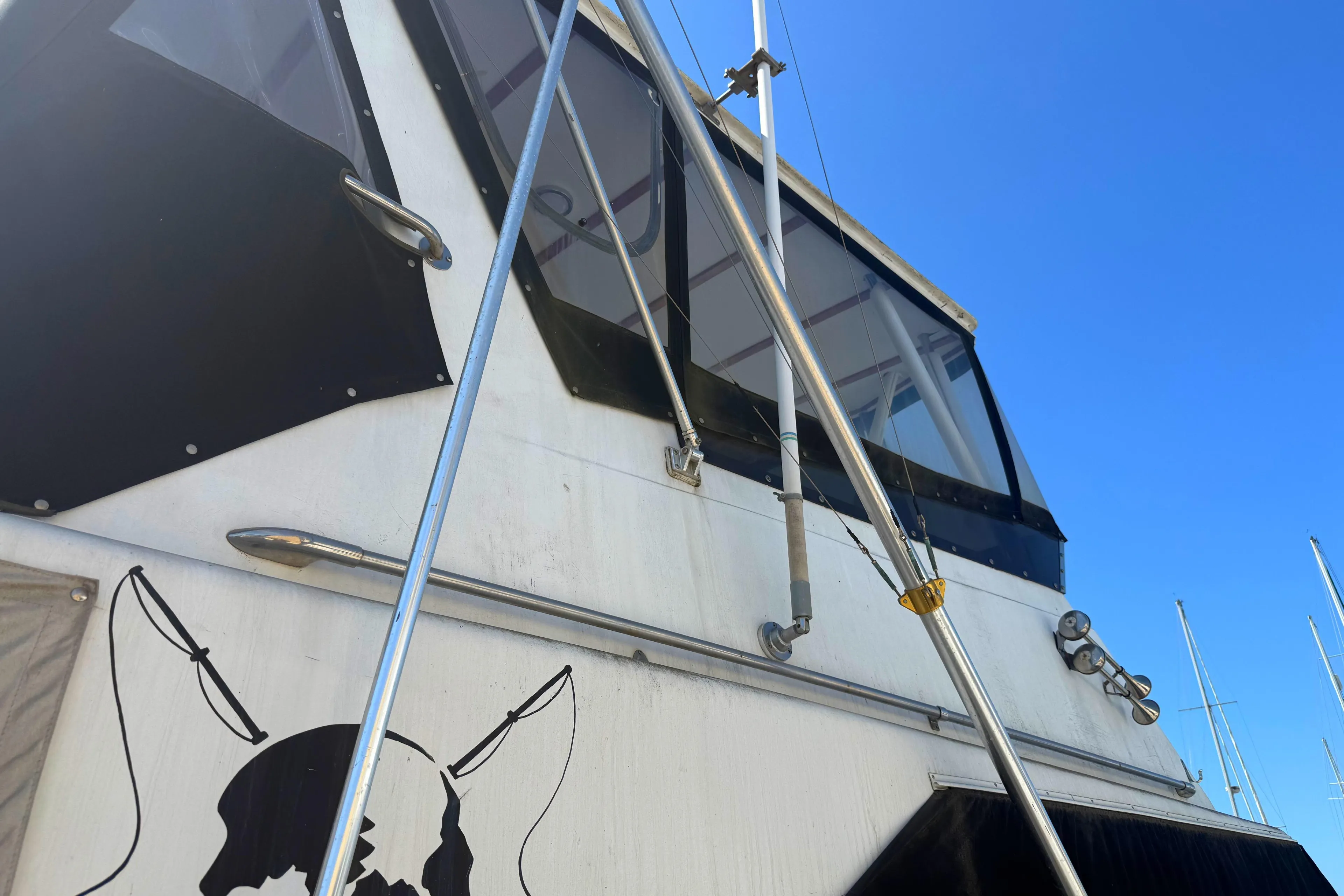 1974 Pacemaker 48 Sportfisherman boat exterior with fishing rods and clear blue sky.