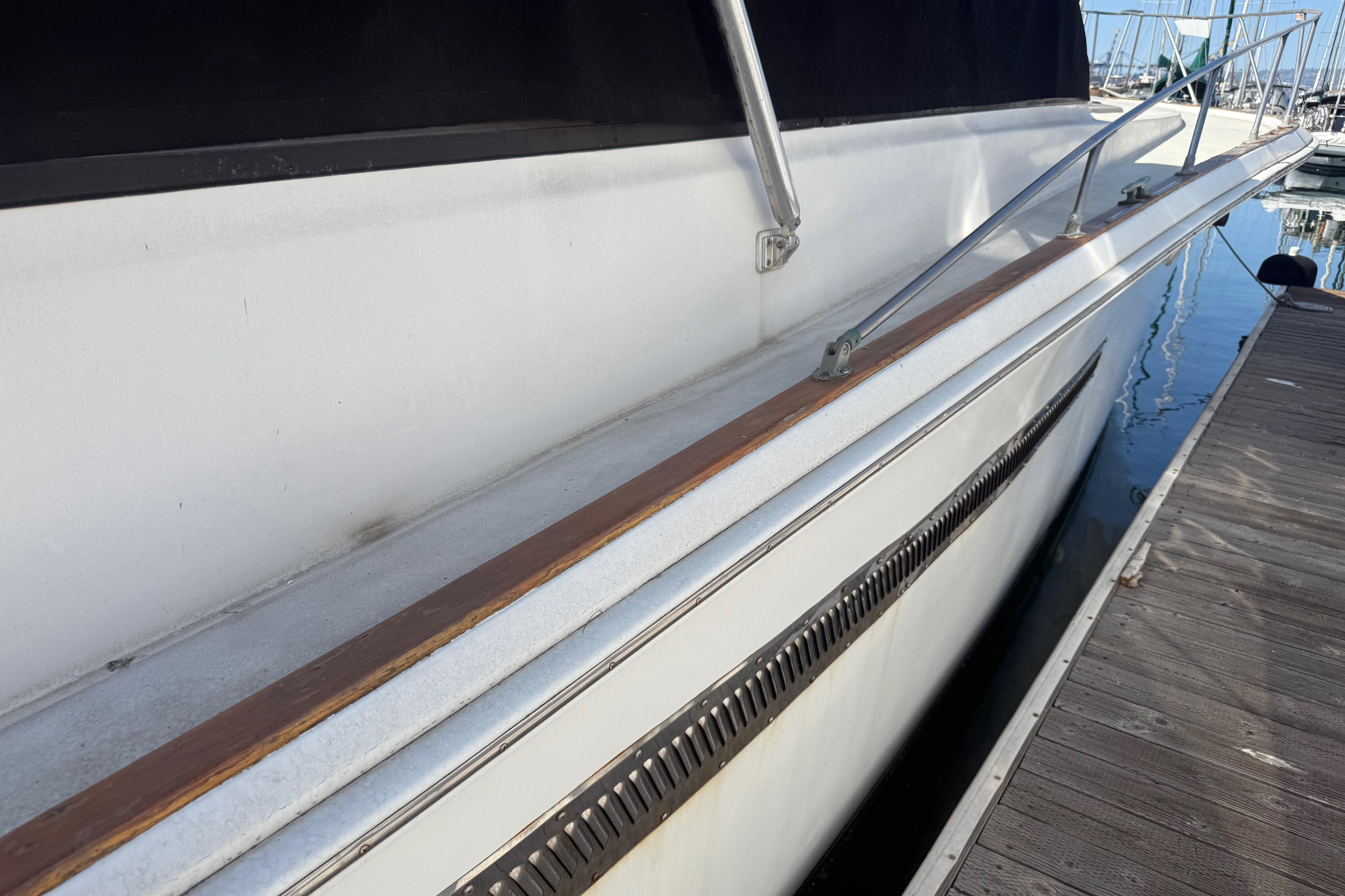 1974 Pacemaker 48 Sportfisherman yacht docked, showcasing sleek side view and railing.
