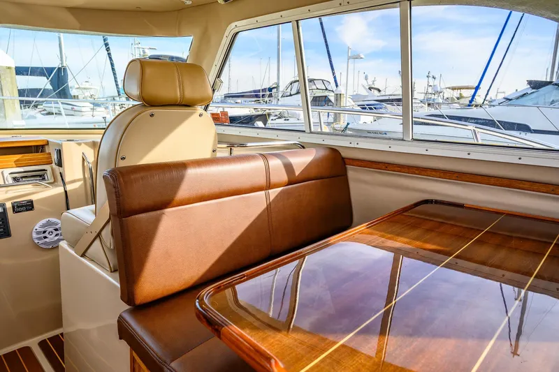  Yacht Photos Pics Interior of 2012 Aspen C90 yacht with leather seating and wooden table, docked at marina.