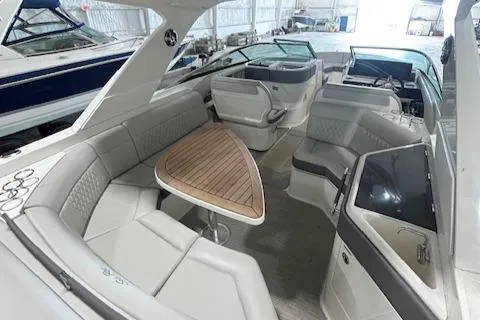  Yacht Photos Pics 2021 Sea Ray SLX 310 boat interior with luxurious seating and wooden table.