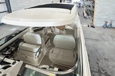  Yacht Photos Pics 2021 Sea Ray SLX 310 boat interior with white seating and helm, in a warehouse setting.