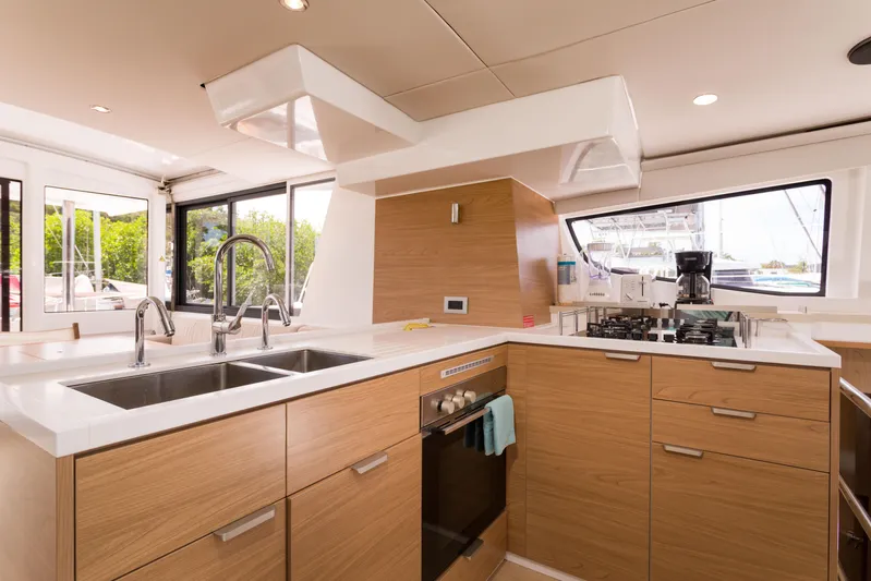 Tikka Yacht Photos Pics Modern kitchen interior on 2024 Bali 4.6 yacht with wood cabinetry and dual sinks.