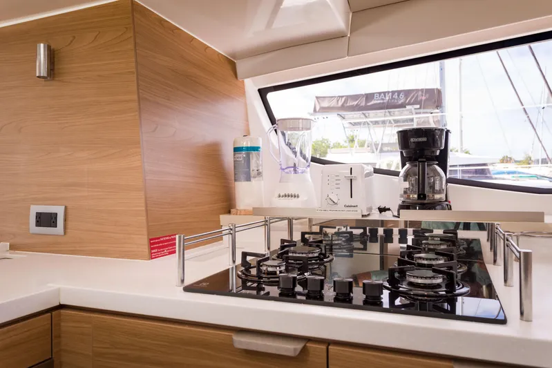 Tikka Yacht Photos Pics Modern kitchen in 2024 Bali 4.6 yacht with stove, coffee maker, and wooden cabinetry.