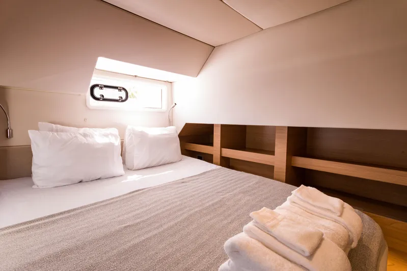 Tikka Yacht Photos Pics Luxurious cabin interior of 2024 Bali 4.6 yacht with cozy bedding and natural light.