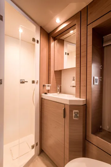Tikka Yacht Photos Pics Modern bathroom in 2024 Bali 4.6 yacht with wooden cabinetry and glass shower.