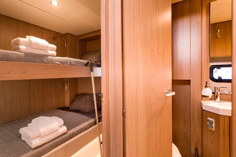 Tikka Yacht Photos Pics Luxurious 2024 Bali 4.6 yacht interior with cozy bunk beds and modern bathroom.