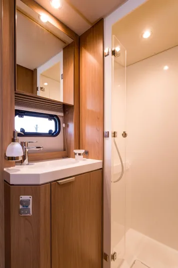 Tikka Yacht Photos Pics Modern bathroom in 2024 Bali 4.6 model yacht with wooden cabinetry and glass shower.