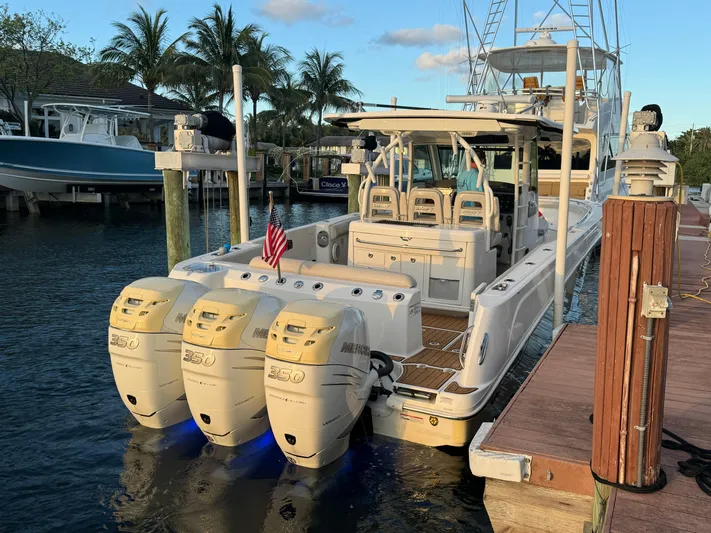  Yacht Photos Pics 2017 Boston Whaler 370 Outrage docked, featuring triple outboard engines, palm trees in background.