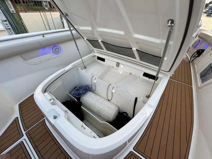  Yacht Photos Pics Open storage compartment on a 2017 Boston Whaler 370 Outrage boat, featuring teak flooring.