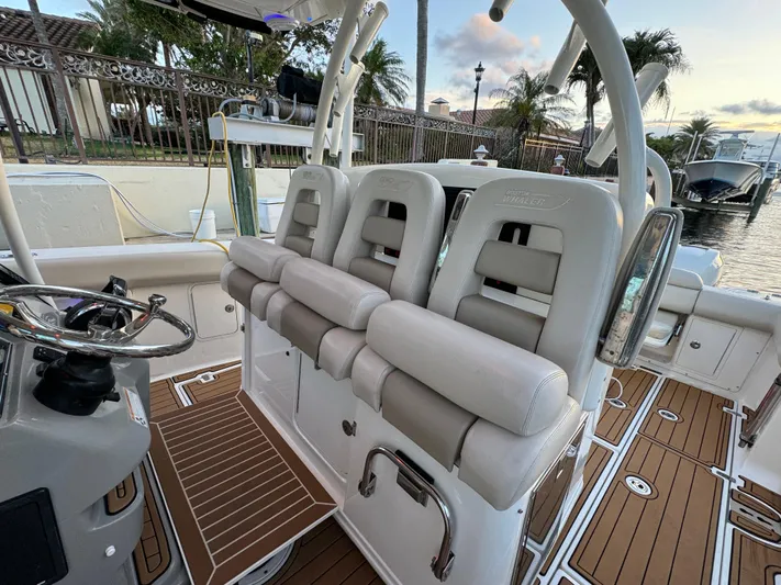  Yacht Photos Pics 2017 Boston Whaler 370 Outrage boat interior with cushioned seating and steering wheel.