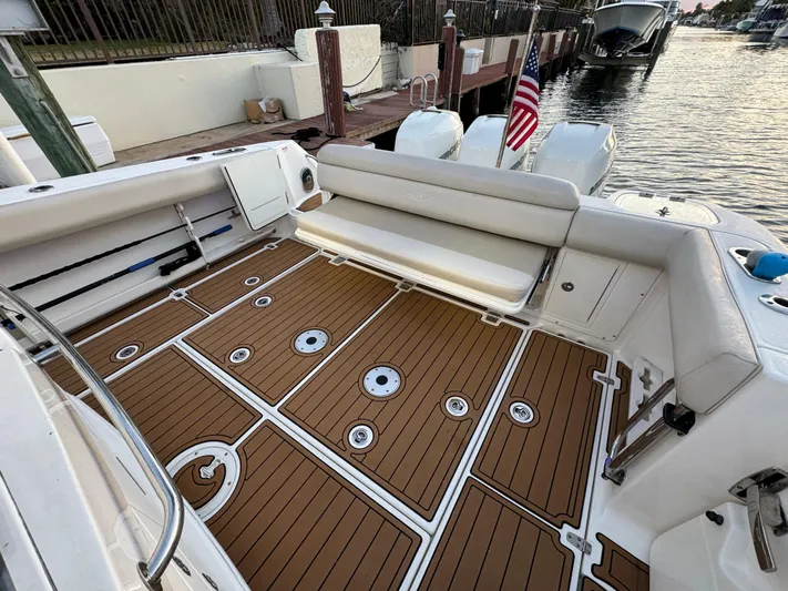  Yacht Photos Pics 2017 Boston Whaler 370 Outrage boat with teak deck and seating, docked by the water.