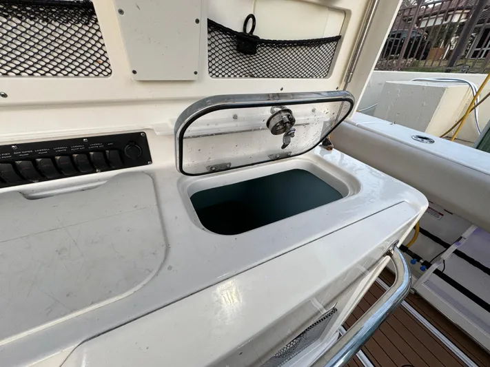  Yacht Photos Pics 2017 Boston Whaler 370 Outrage boat with open storage compartment and control panel.