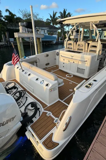  Yacht Photos Pics 2017 Boston Whaler 370 Outrage boat with spacious deck and seating, docked by palm trees.