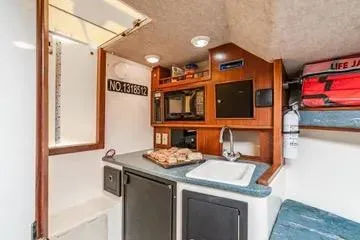 Jesses Girl Yacht Photos Pics 2005 Carolina Classic 28 boat interior with kitchenette, sink, and storage.
