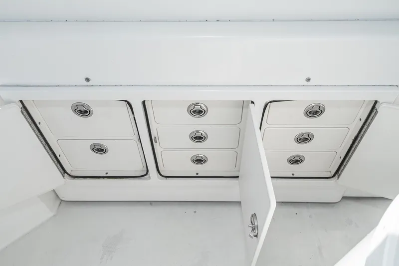 Jesses Girl Yacht Photos Pics 2005 Carolina Classic 28 boat storage compartments with open doors, showcasing organized interior.