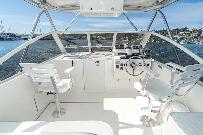 Jesses Girl Yacht Photos Pics 2005 Carolina Classic 28 boat cockpit with steering wheel, chairs, and ocean view.