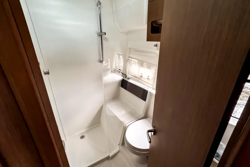 Yacht Photos Pics 2022 Beneteau Antares 11 Fly bathroom with shower and toilet, modern design.