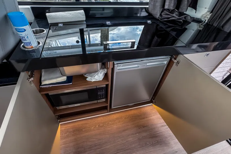  Yacht Photos Pics Modern kitchen area in 2022 Beneteau Antares 11 Fly yacht with appliances and storage.