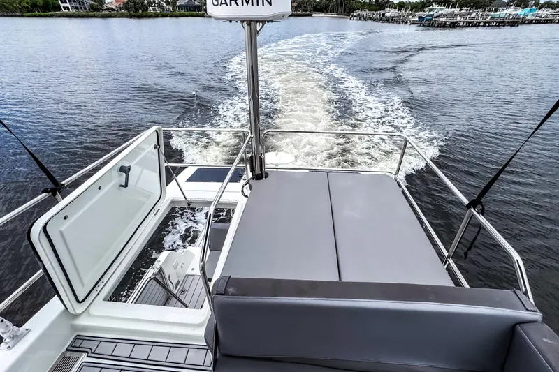  Yacht Photos Pics 2022 Beneteau Antares 11 Fly cruising on water, rear view with open deck.