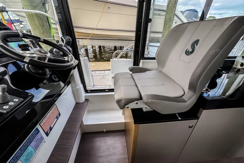  Yacht Photos Pics Interior helm of 2022 Beneteau Antares 11 Fly with steering wheel and captain's seat.