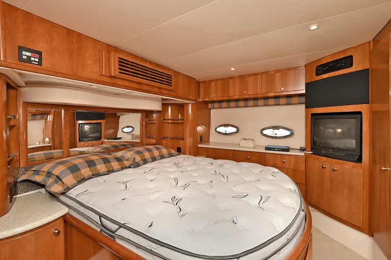  Yacht Photos Pics Luxurious 2001 Carver 466 Motor Yacht bedroom with wood cabinetry and cozy bedding.