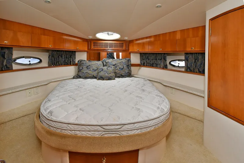 Yacht Photos Pics Interior of 2001 Carver 466 Motor Yacht bedroom with bed and wooden cabinetry.