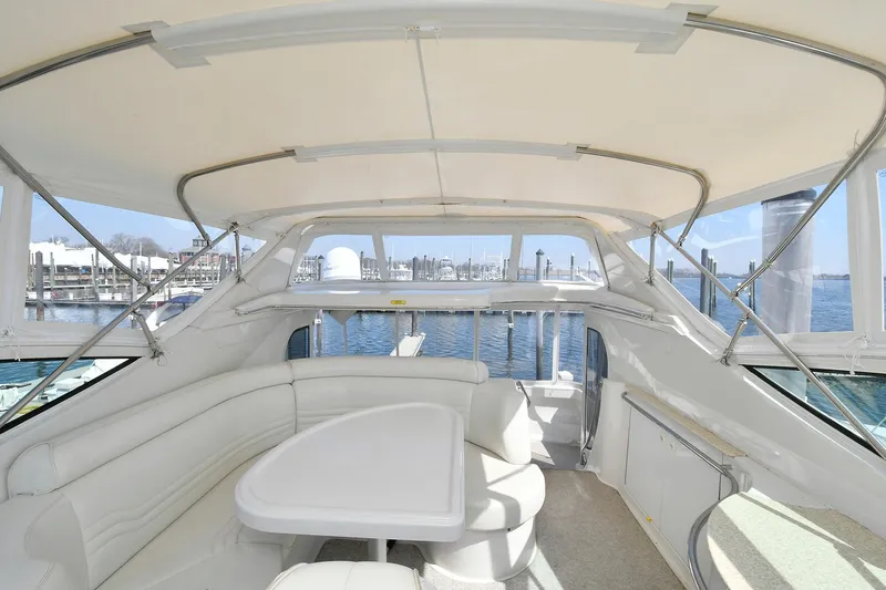  Yacht Photos Pics 2001 Carver 466 Motor Yacht interior with white seating and table, overlooking marina.