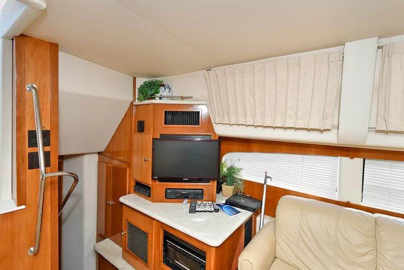  Yacht Photos Pics Interior of 2001 Carver 466 Motor Yacht with TV, beige sofa, and wooden cabinetry.