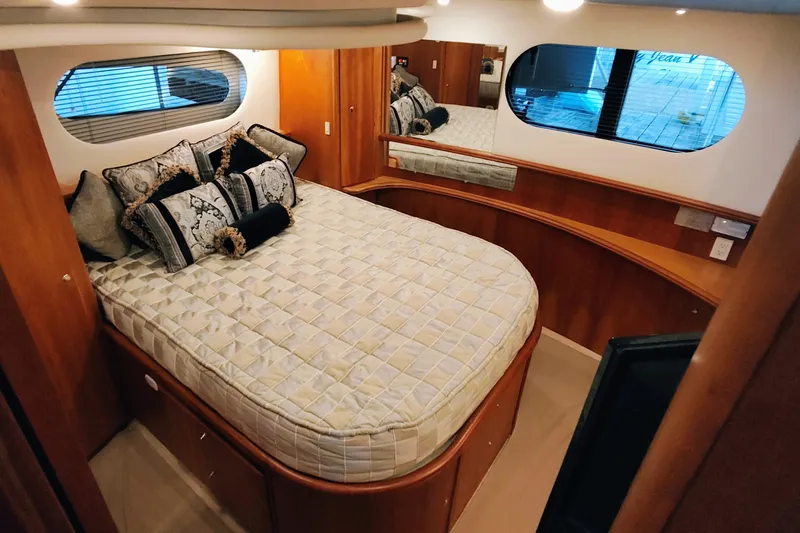 Diversion III Yacht Photos Pics Luxurious bedroom interior of 2002 Silverton 43 Motor Yacht with elegant bedding and wood accents.