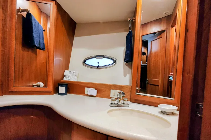 Diversion III Yacht Photos Pics Luxurious bathroom interior of 2002 Silverton 43 Motor Yacht with wood accents and oval window.