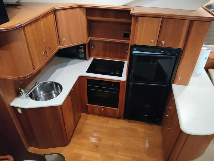 Diversion III Yacht Photos Pics 2002 Silverton 43 Motor Yacht kitchen with wood cabinetry and modern appliances.