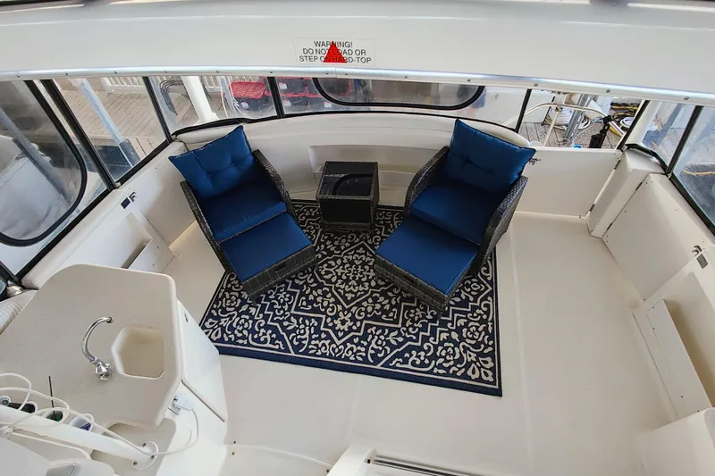 Diversion III Yacht Photos Pics 2002 Silverton 43 Motor Yacht interior with blue cushioned chairs and patterned rug.