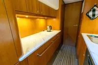 Luxurious 2004 Elling E3 Ultimate yacht kitchen with wood cabinetry and marble countertop.