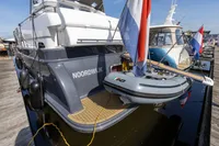 Elling E3 Ultimate 2004 yacht docked, featuring a small boat and flag at the stern.