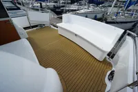 2004 Elling E3 Ultimate yacht deck with white seating and wooden flooring in a marina.