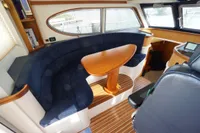 Interior of 2004 Elling E3 Ultimate yacht with curved seating and wooden table.