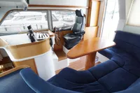 Interior of 2004 Elling E3 Ultimate yacht with helm, seating, and wooden table.