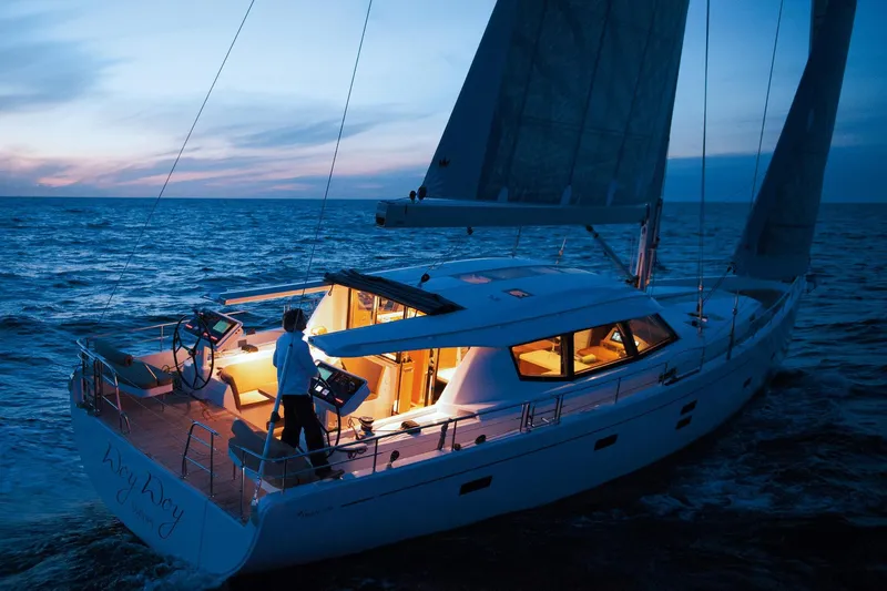  Yacht Photos Pics Sailing yacht Moody DS 54, 2026 model, illuminated at dusk on open sea.