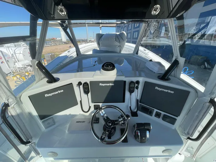 Saltwater Lady Yacht Photos Pics 2016 Yellowfin 42 boat cockpit with Raymarine navigation system and steering wheel.