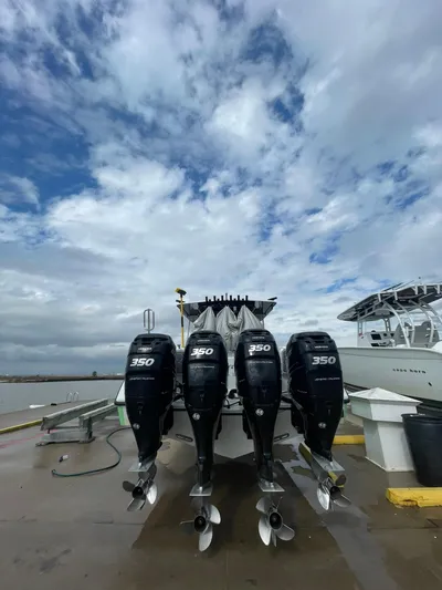 Saltwater Lady Yacht Photos Pics 2016 Yellowfin 42 boat with four powerful outboard engines docked under a cloudy sky.