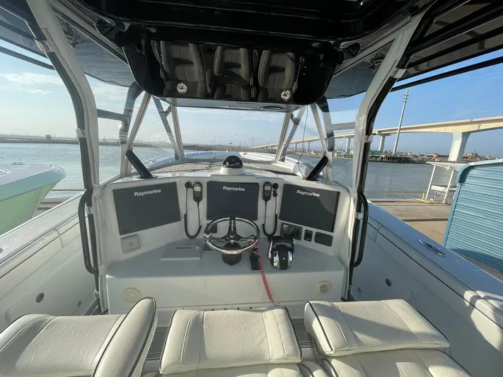 Saltwater Lady Yacht Photos Pics 2016 Yellowfin 42 boat cockpit with dual Raymarine displays, steering wheel, and waterfront view.